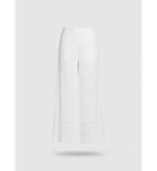 Tenue blanche deux pièces: top col carré à bretelles nouées et pantalon large brodé avec œillets, tissu léger.