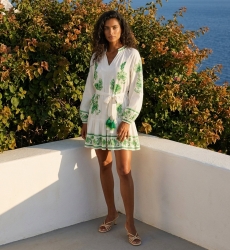 Robe courte blanche manches longues, broderie florale verte, col V, taille nouée à pompons, jupe étagée en tissu léger.