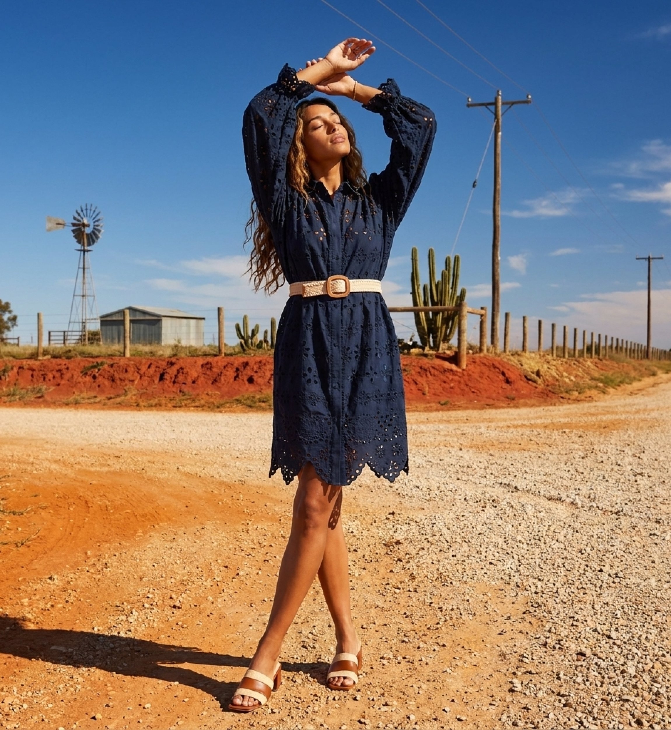 Robe courte bleu marine portée par un mannequin, bras levés, montrant le bustier ajusté et la jupe fluide.