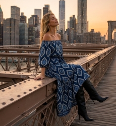 Robe longue bleu marine épaules dénudées motif ikat blanc, volants, manches bouffantes, ceinture, portée au coucher du soleil.