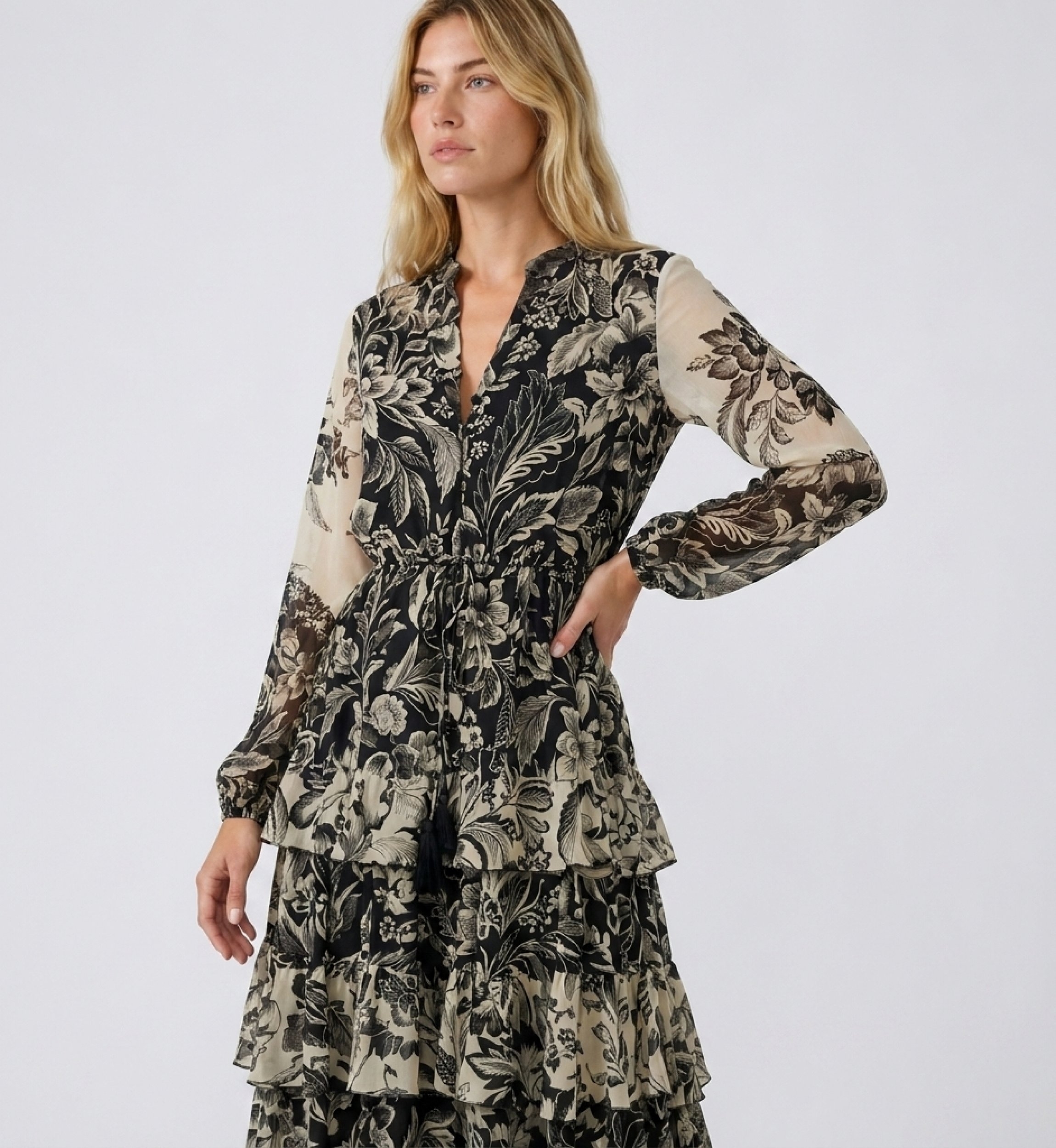 Vestido maxi negro beige floral, cuello V, manga larga, cintura elástica, falda volantes, tela ligera, vista tres-cuartos.