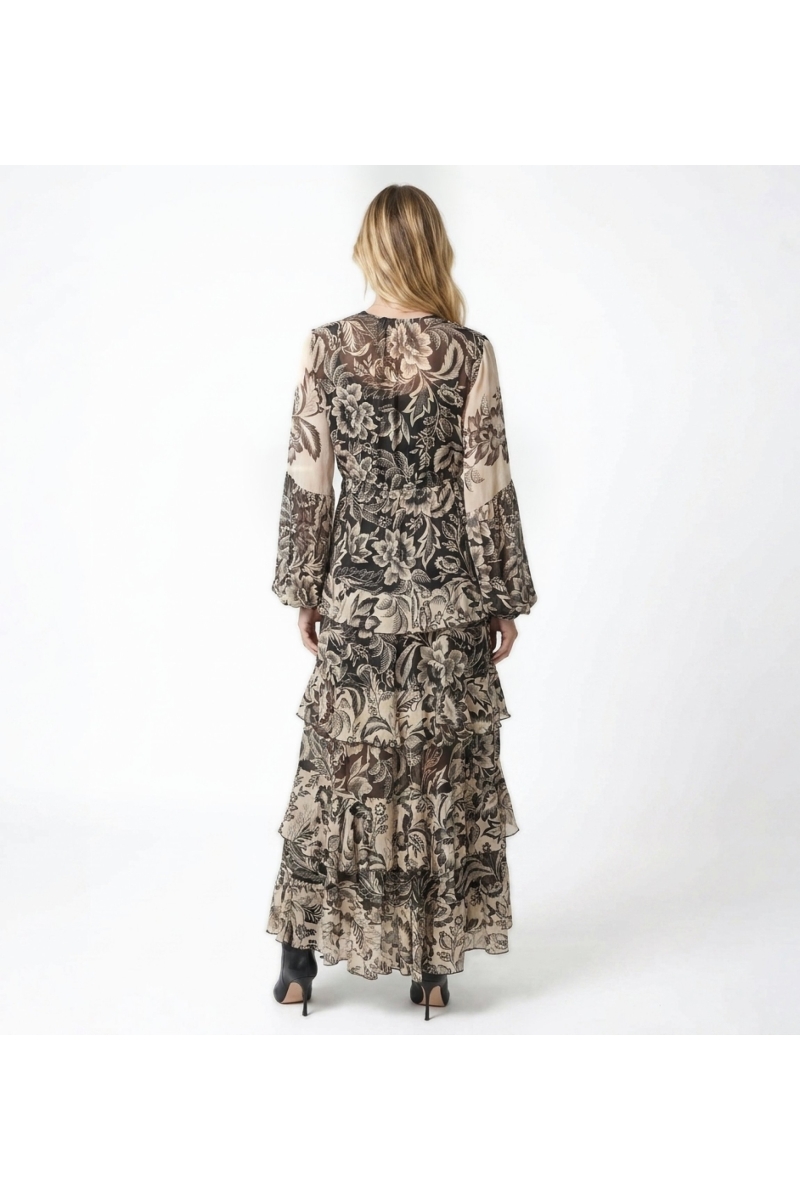 Vista trasera de vestido largo maxi negro y beige con estampado floral, manga larga, cintura elástica y falda con volantes.