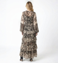 Vista trasera de vestido largo maxi negro y beige con estampado floral, manga larga, cintura elástica y falda con volantes.