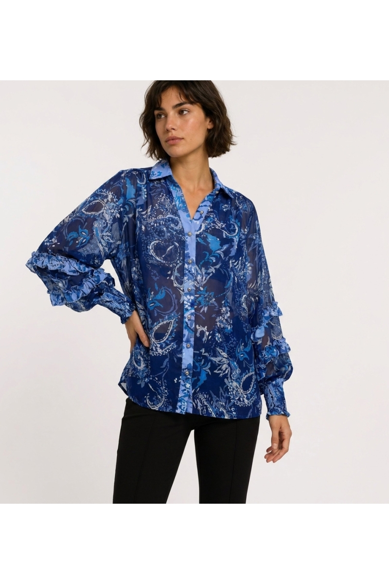 Vue trois-quarts d'une blouse transparente bleue à manches longues, motif cachemire floral, poignets volantés, col V.