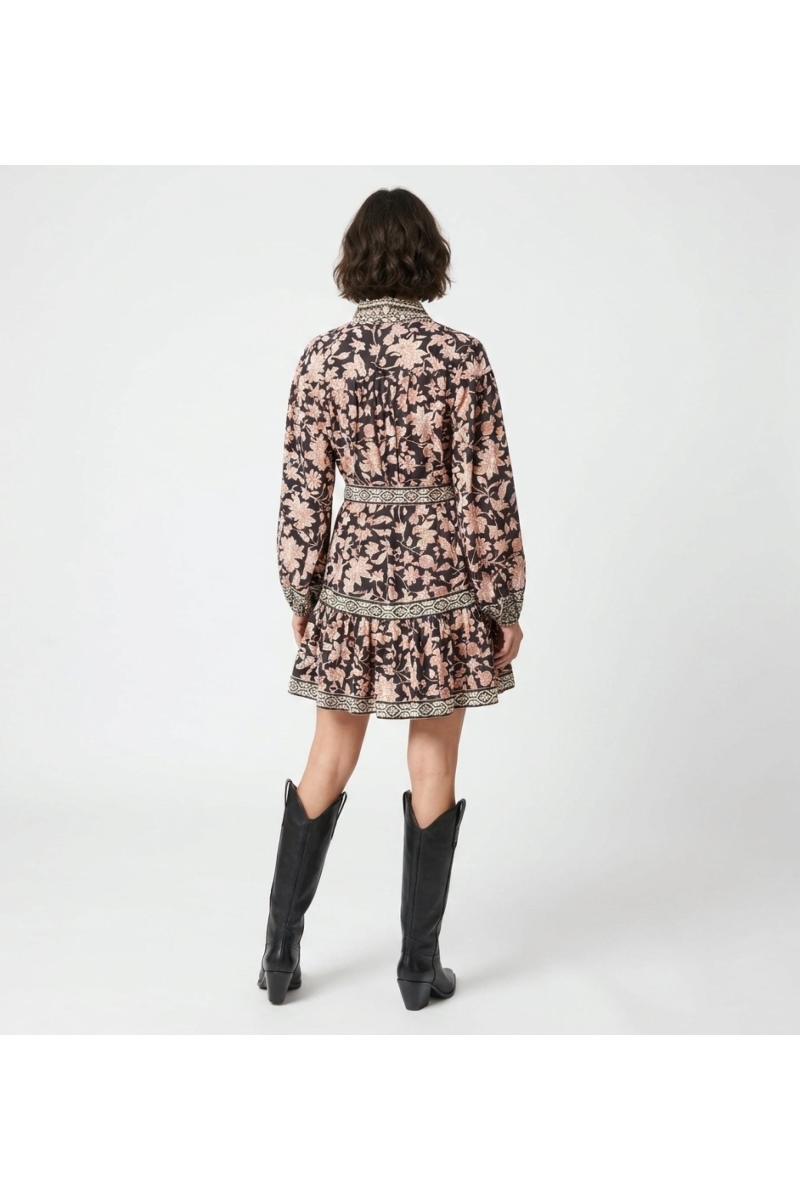Vista trasera de vestido mini negro manga larga con cuello, estampado floral rojo y crema, cinturón anudado y falda de volantes.