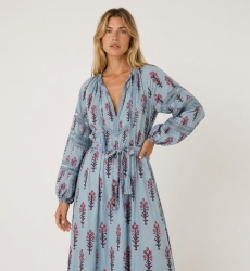 Vestido midi azul claro con estampado floral, vista tres cuartos. Mangas largas abullonadas, escote en V, cintura con borlas.