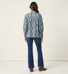 Chemisier bleu clair à fleurs, vue dos. Motif floral rose et marron, manches ballon avec dentelle, poignets smockés.