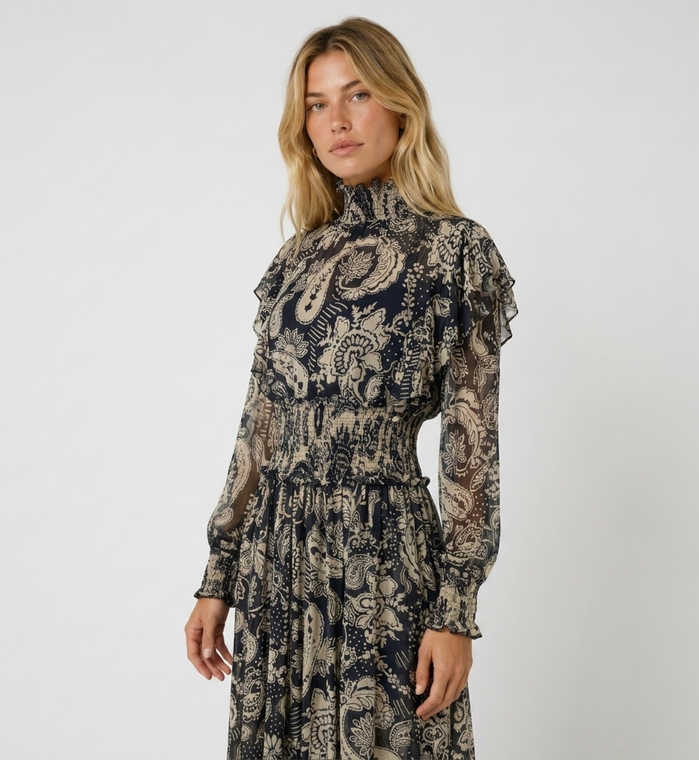 Robe midi à manches longues, imprimé cachemire noir et beige, col volanté, taille smockée, tissu transparent. Vue 3/4.