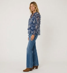 Blusa azul transparente de manga larga con estampado floral, volantes en hombros y puños, cuello con cordón, vista tres cuartos.