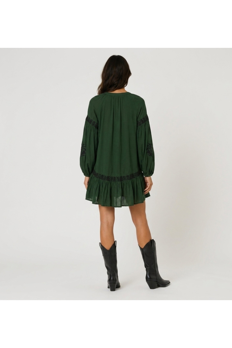 Robe courte vert foncé à col, broderie florale noire, taille nouée, manches longues volumineuses, vue de dos.