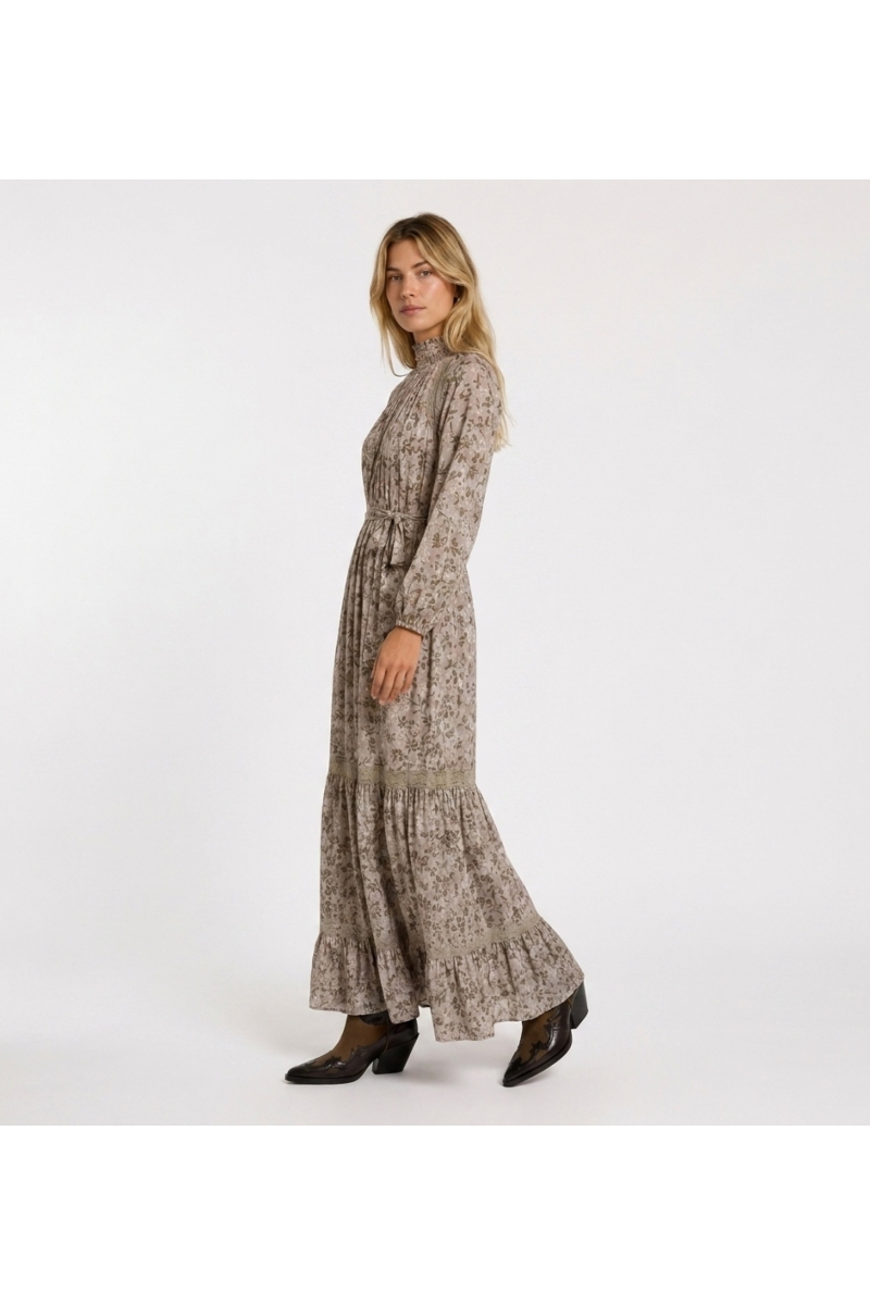 Robe longue maxi rose pâle à motifs floraux et feuilles vertes dorées, col smocké, manches bouffantes, dentelle.