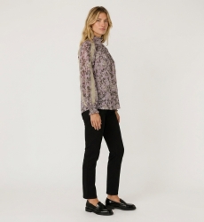 Vue trois-quarts d'une blouse violette à manches longues, col montant, motif floral sombre, dentelle beige et poignets smockés.