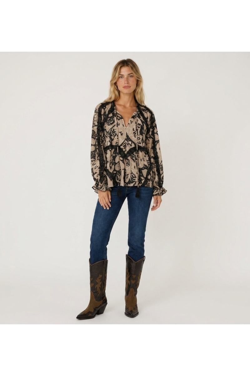 Blouse ample à manches longues motif beige et noir, détails volants et pompons, tissu léger, vue de face.