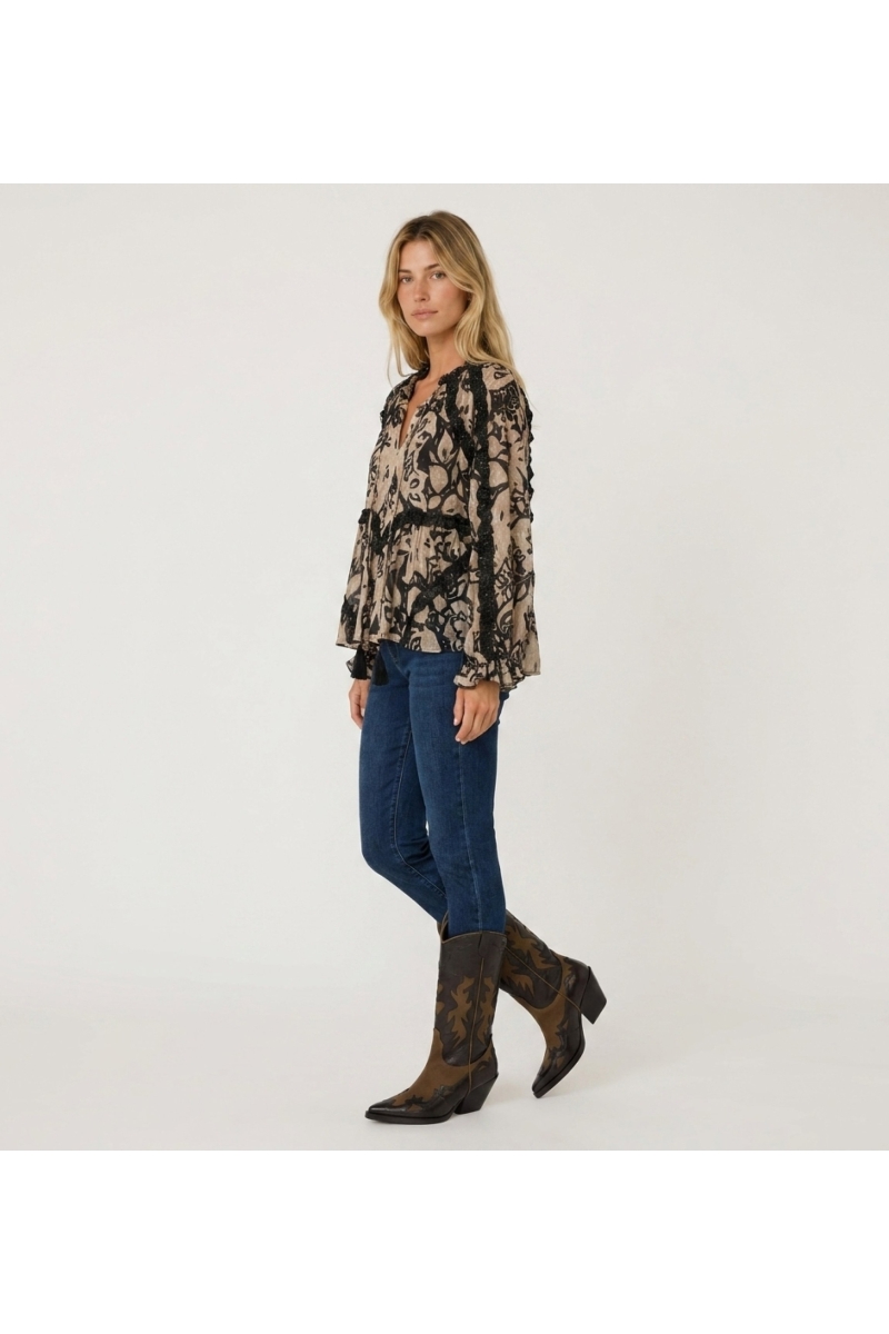 Blouse ample à manches longues beige et noire imprimée, avec volants et pompons, tissu léger.