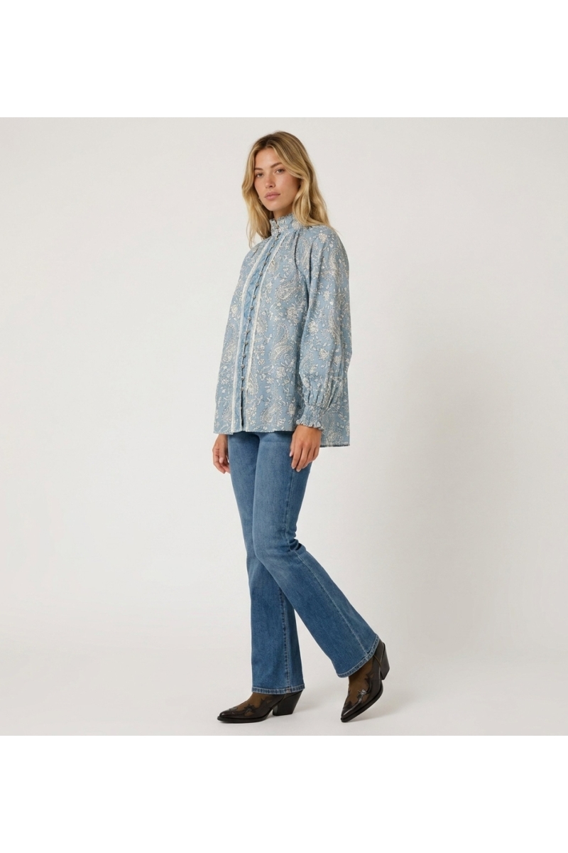 Blusa mujer azul claro manga larga, estampado cachemir, cuello alto, abotonada, puños con volantes.