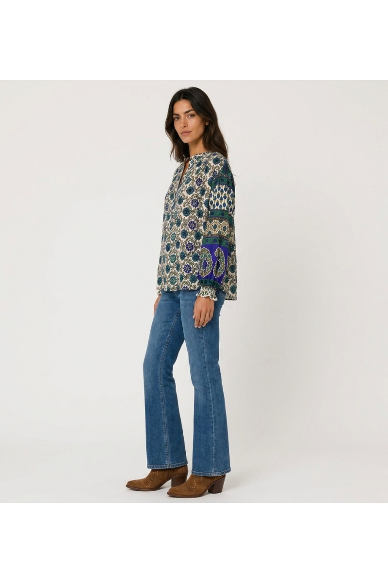 Three-quarter view: Cream long-sleeve blouse, blue and green floral pattern, contrasting balloon sleeves, lightweight fabric.
