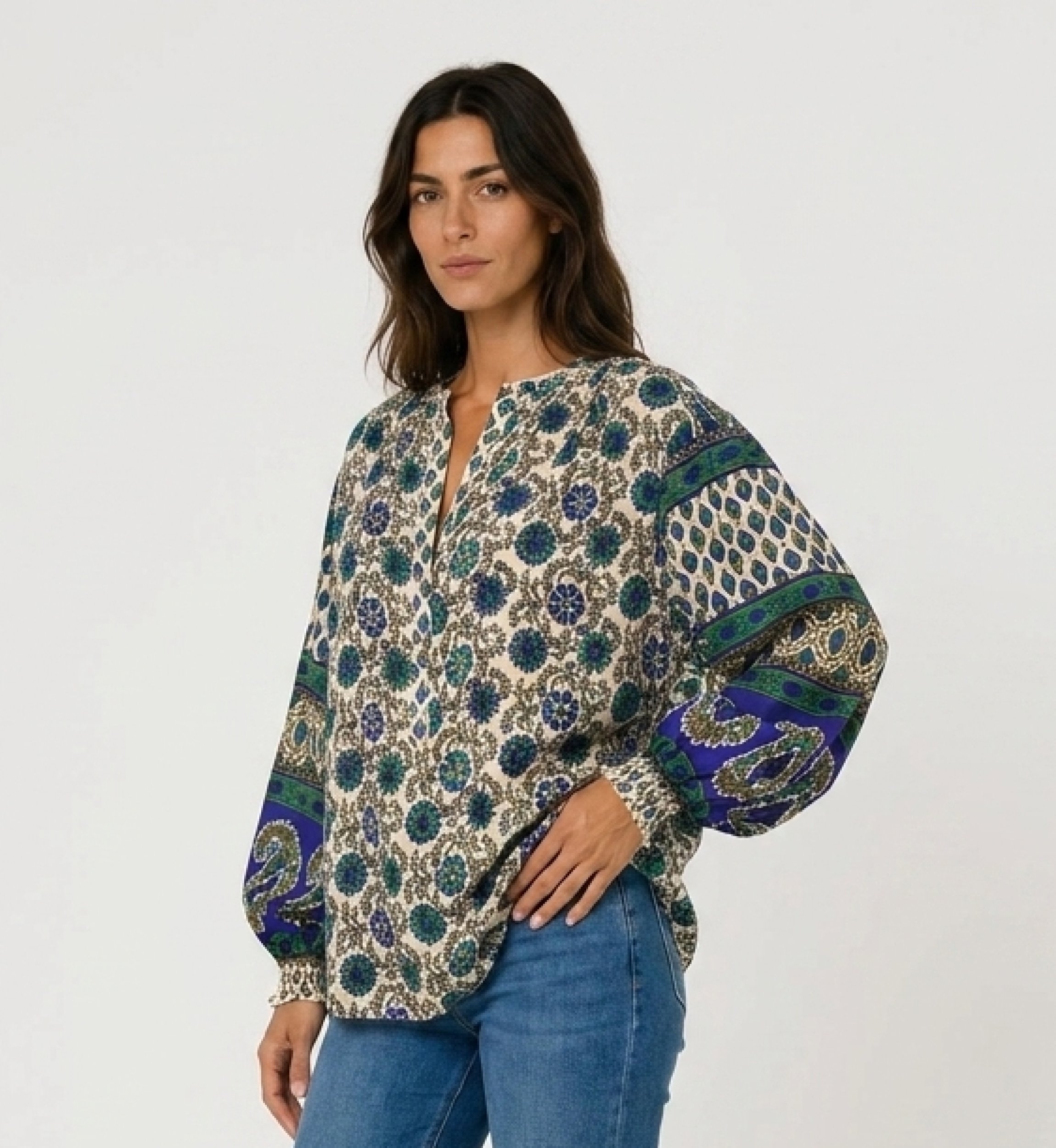 Blusa crema de manga larga con estampado floral azul y verde. Tejido ligero, mangas abullonadas contrastantes. Vista 3/4.