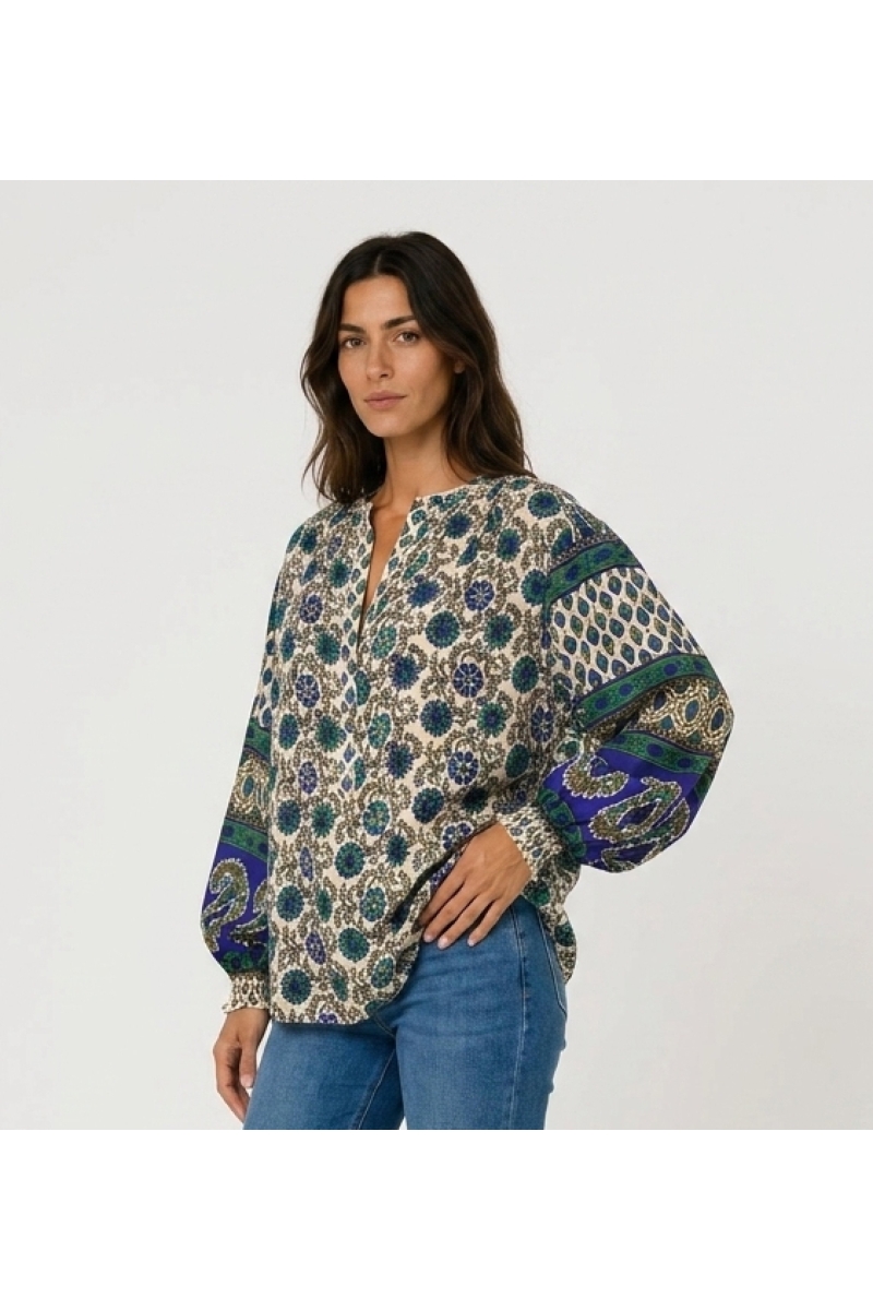 Blouse écru manches longues, motif floral bleu vert. Tissu léger, manches ballon contrastantes. Vue trois-quarts.