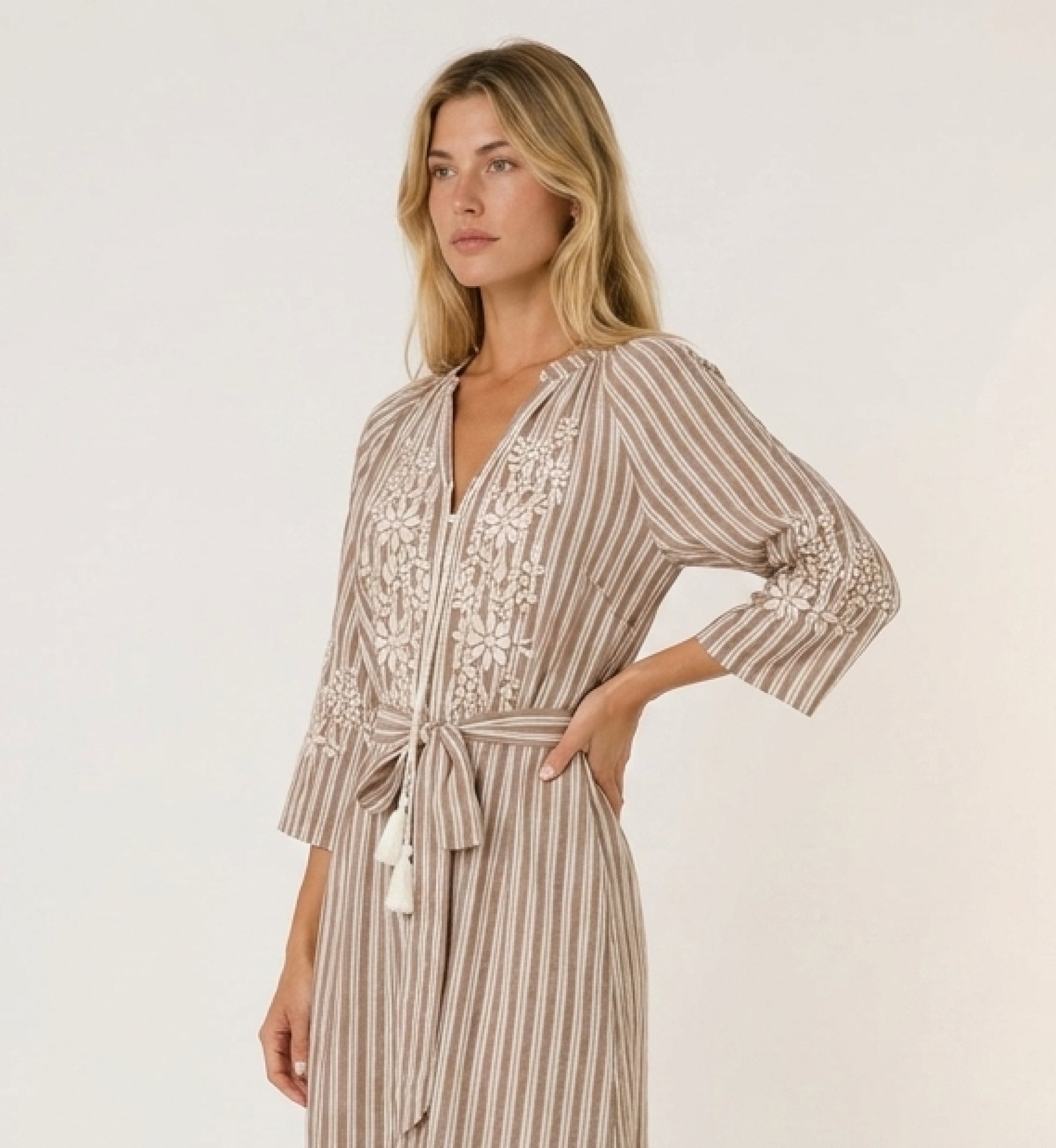 Robe midi rayée marron et blanc, jupe à volants, broderie florale blanche et taille nouée avec pompons, vue de côté.