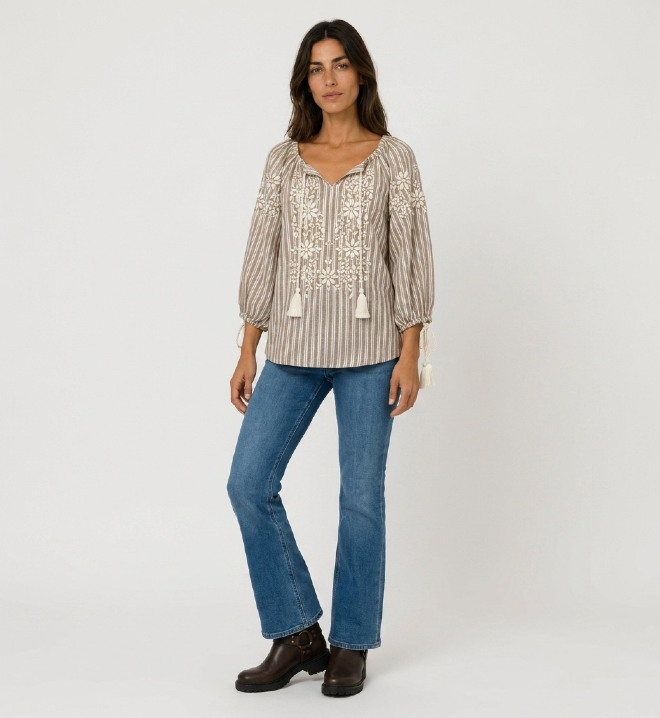 Blusa campesina rayas marrón y blanco, escote V, mangas 3/4 abullonadas, bordado floral blanco y borlas, vista frontal.