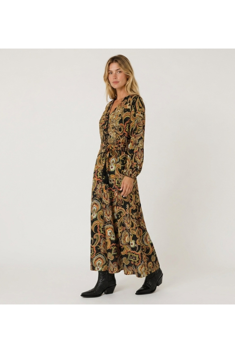 Black long-sleeve maxi dress with colorful paisley pattern, V-neck, tie-waist and flowing fabric, three-quarter view.