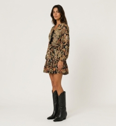 Black long-sleeve mini dress with colorful paisley pattern, tie-neckline, cinched waist, and ruffled hem, three-quarter view.