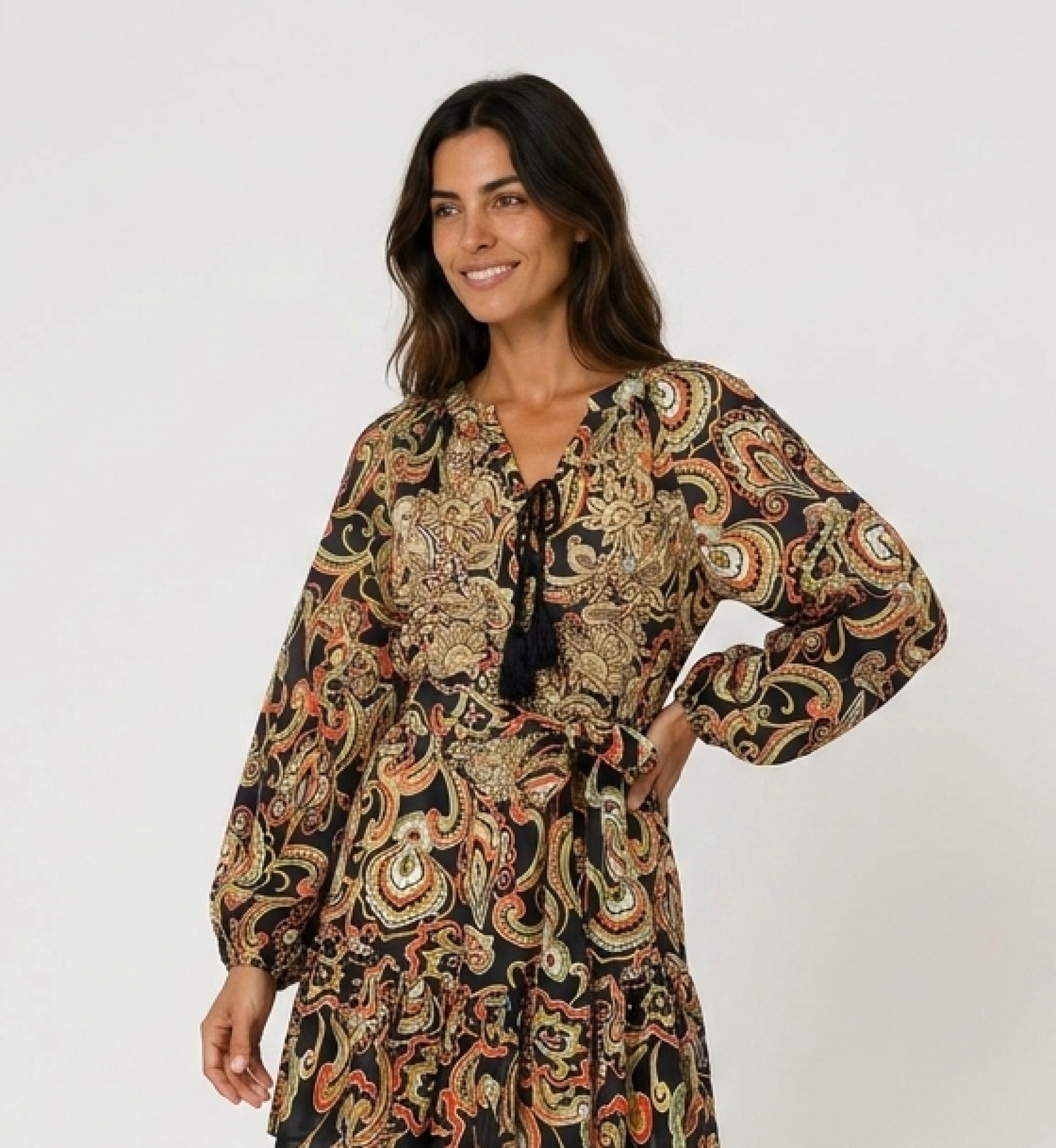Mini-robe noire à manches longues, imprimé cachemire coloré, col à nouer avec pompons, taille cintrée et ourlet volanté.