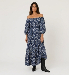 Robe longue marine à épaules dénudées, motif ikat blanc/bleu clair, volants, manches bouffantes et ceinture nouée.