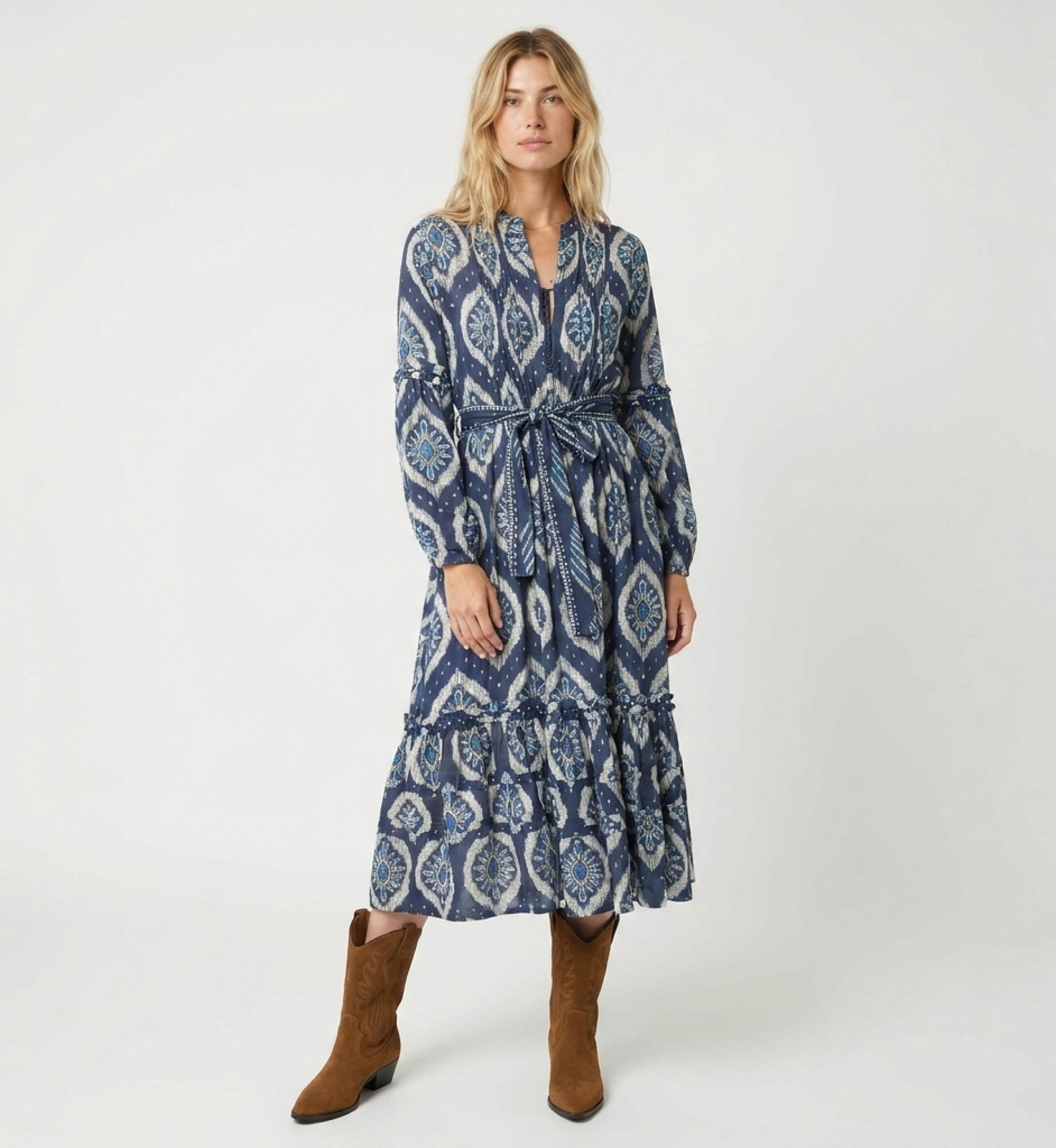 Front view of a blue and white ikat pattern midi dress with long puff sleeves, tiered skirt, and tie belt.