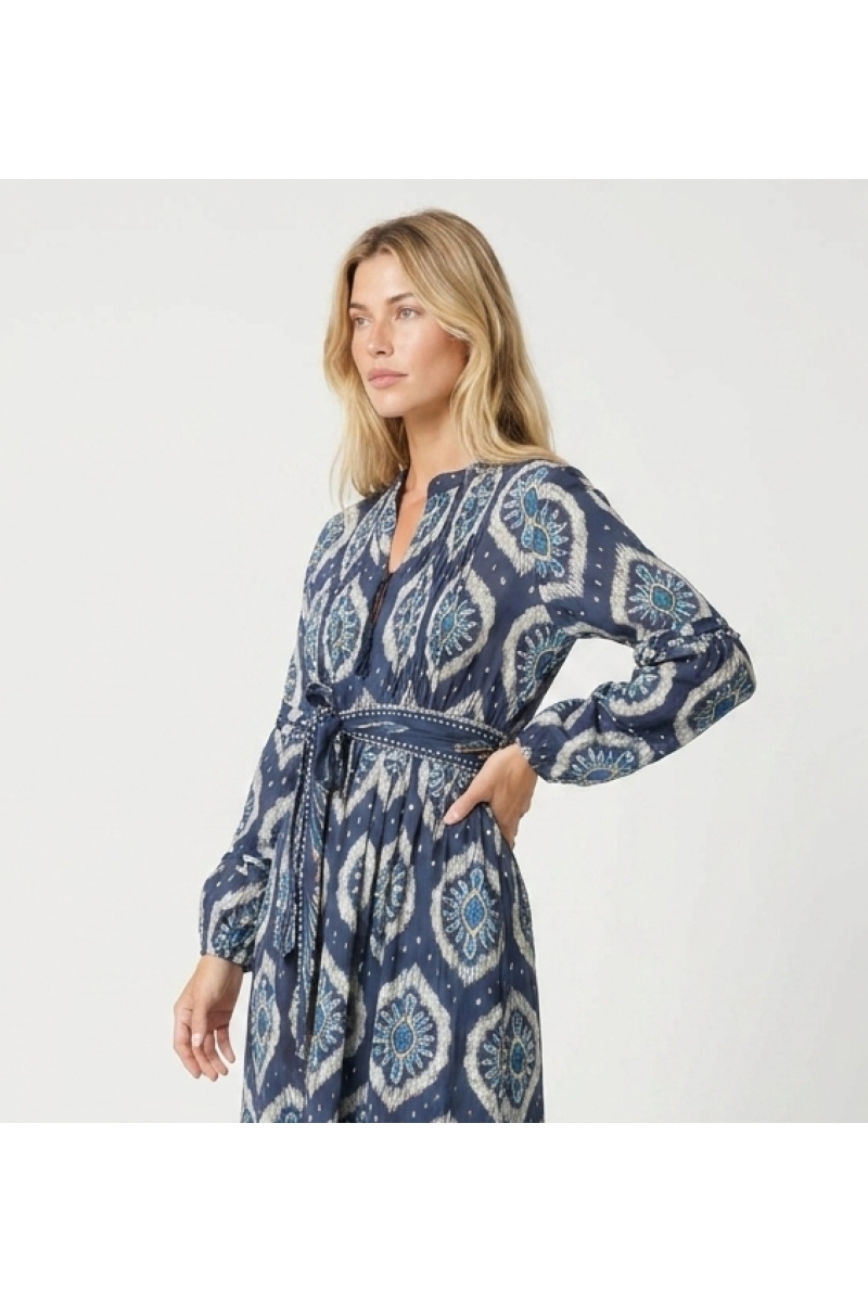 Vue trois-quarts d'une robe midi ikat bleue et blanche à manches longues bouffantes, jupe étagée et ceinture.