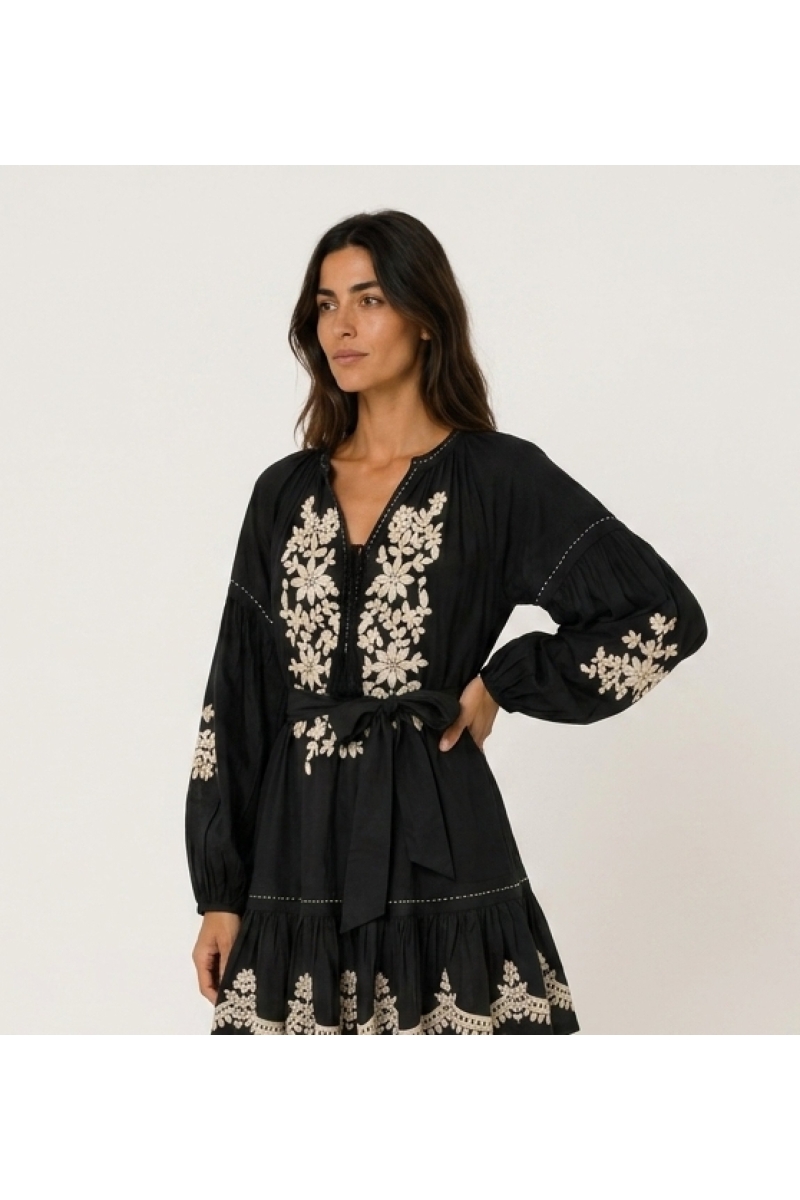 Black loose fit mini dress with long balloon sleeves, tiered skirt, white floral embroidery, and tie-waist.