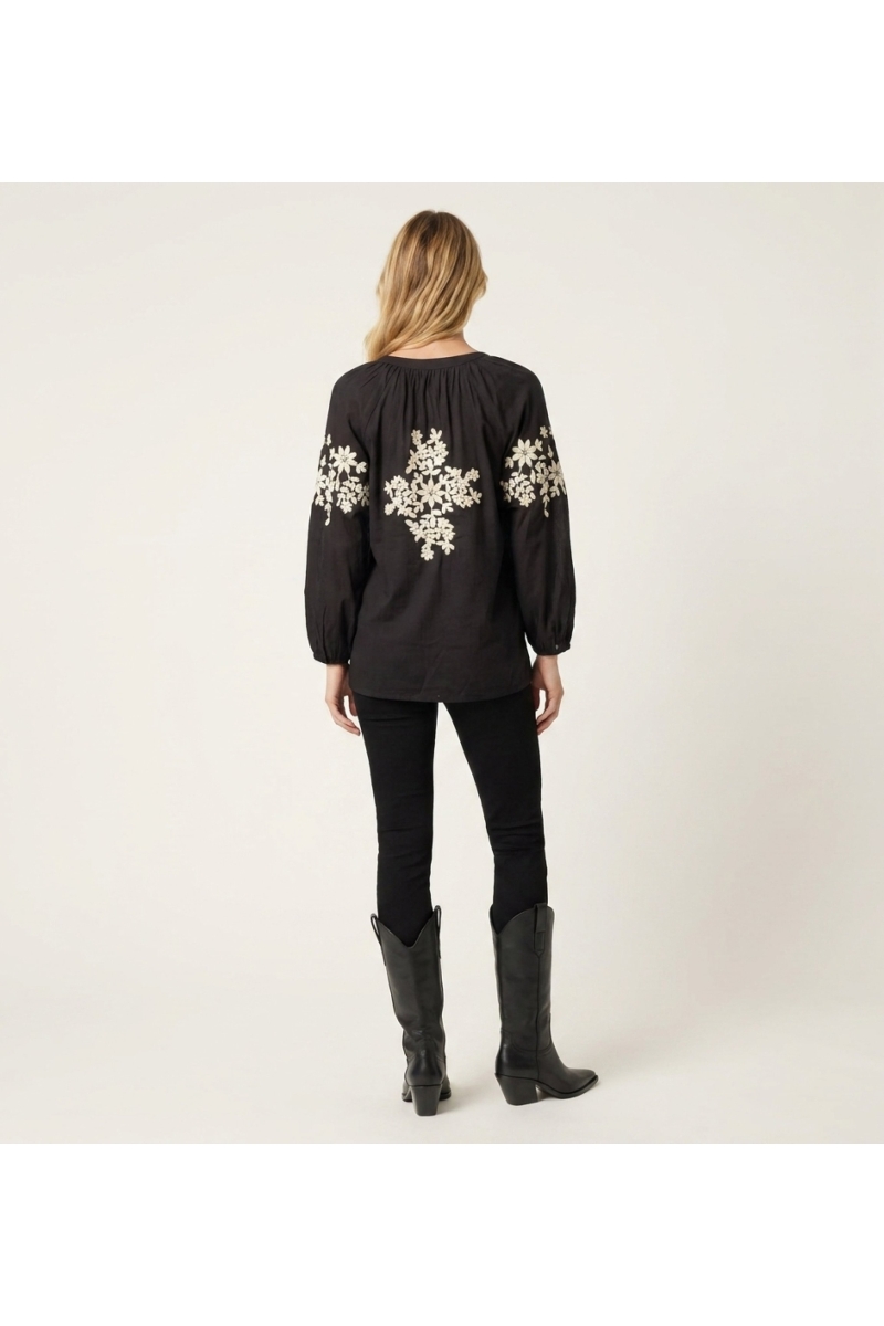 Blusa campesina negra de manga larga efecto lino, bordado floral crema, vista detallada de espalda.