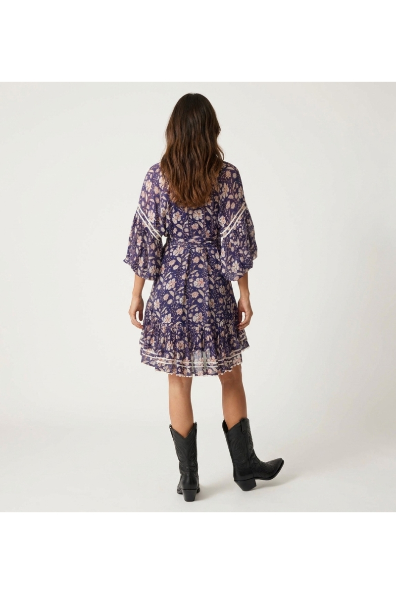 Back view of sheer navy floral mini dress with balloon sleeves, collared V-neck, tiered skirt, and tie-belt.