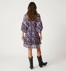 Dos d'une mini-robe transparente bleu marine à fleurs roses/blanches, manches ballon, col V, jupe à volants, ceinture nouée.
