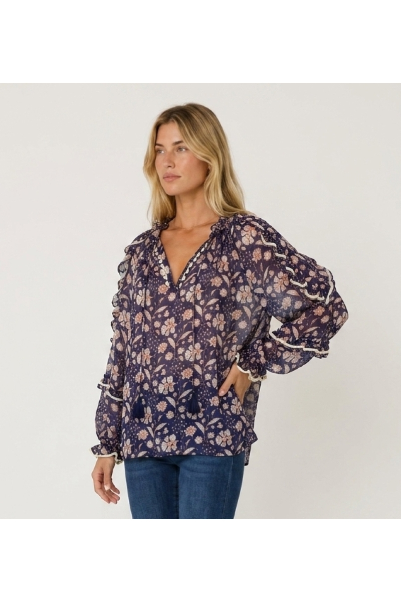 Sheer navy blue floral blouse with white and peach print, ruffled long sleeves, V-neck with ties, loose fit, three-quarter view.