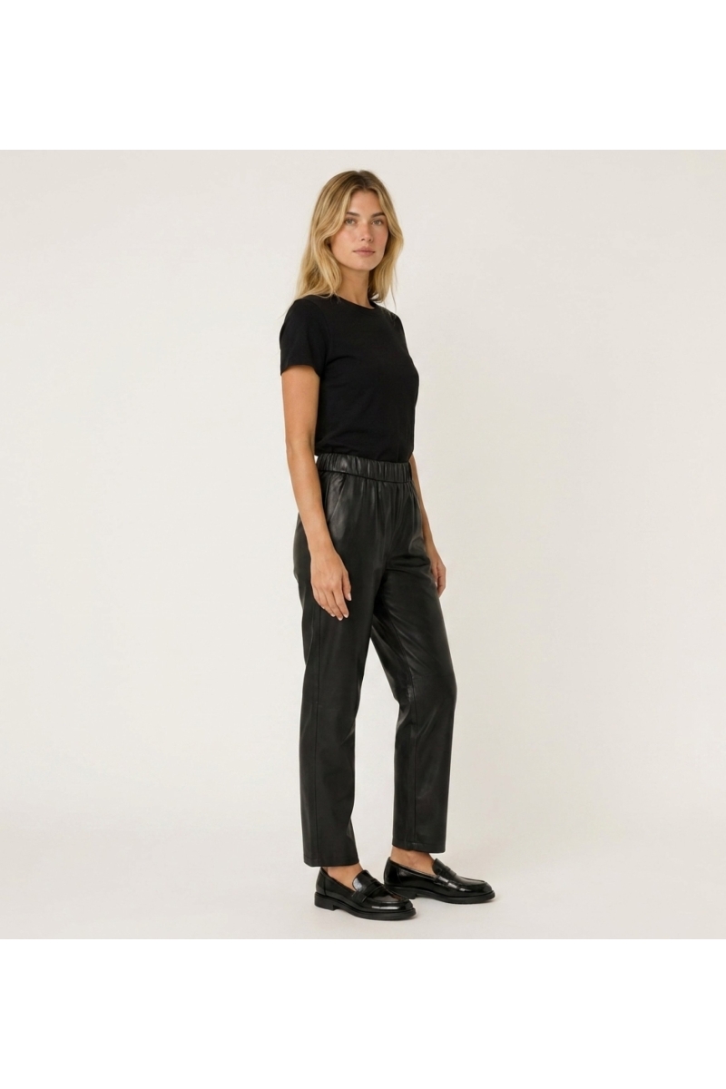 Pantalon en cuir élégant pour femme, présenté en vue de trois-quarts de côté. Coupe moderne et ajustée.