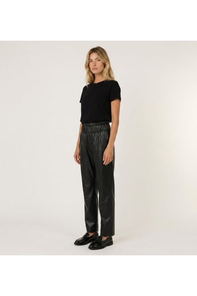 Pantalón de cuero negro para mujer, corte ajustado, vista lateral de tres cuartos, mostrando su estilo y textura.