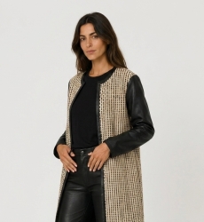 Chaqueta larga sin cuello, abierta, de tejido negro y beige, con mangas y ribetes de polipiel negra.
