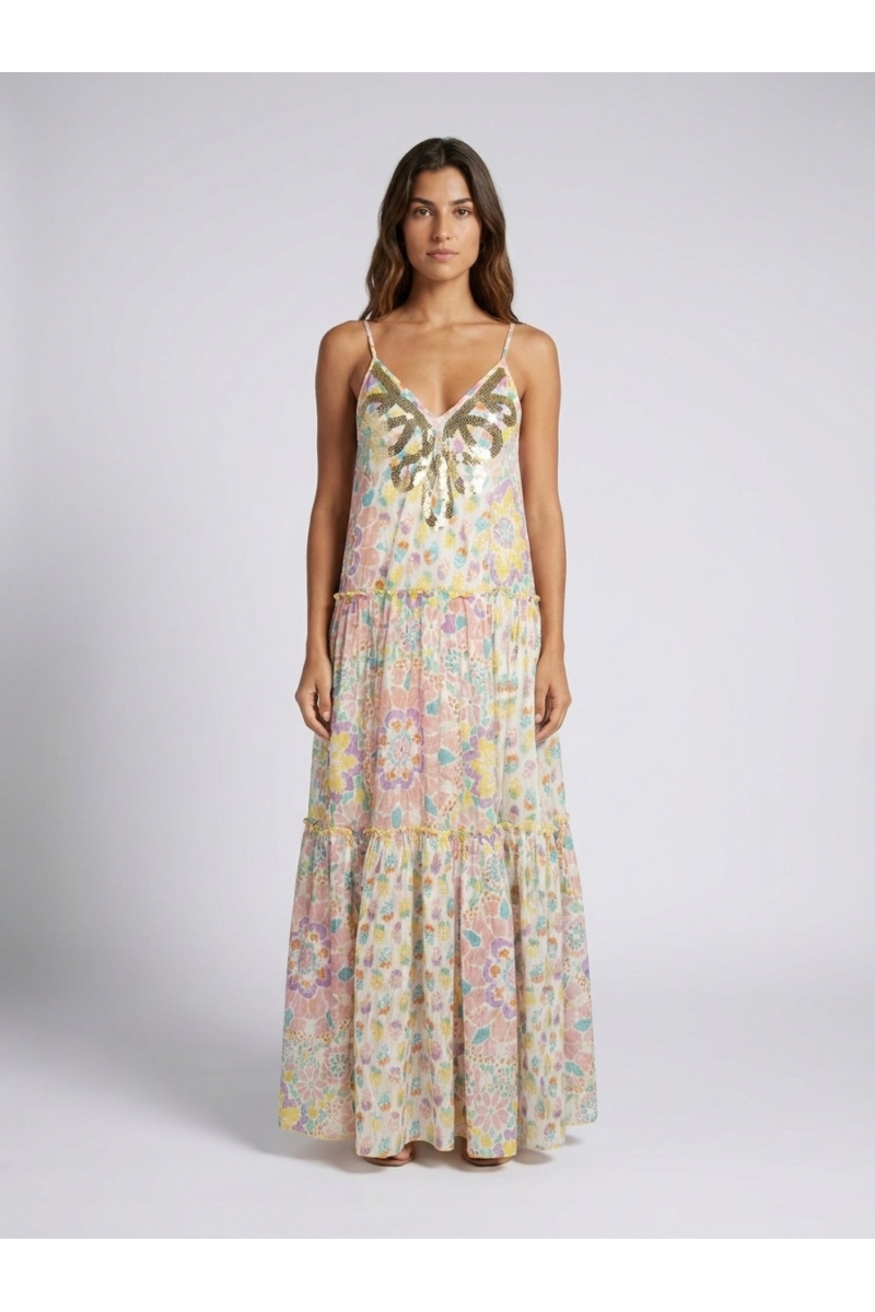 Front view: White tiered maxi dress with thin straps, V-neck, and vibrant multicolored floral print. Sequin embellished neckline